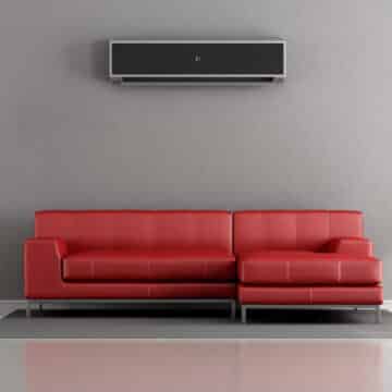 How to Cool the Upstairs of a Two-Story Home. Living room with red sofa and ductless unit.